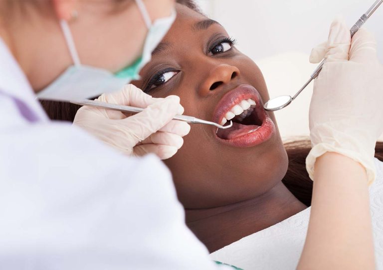African American woman getting dental examination