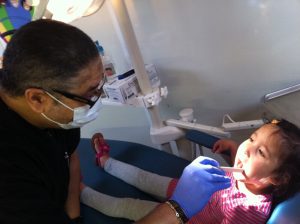 Dr. David Lamothe examining a child's teeth